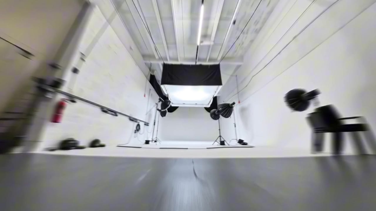 Studio A during a live shoot, seen wide across the white infinity cove with softboxes either side